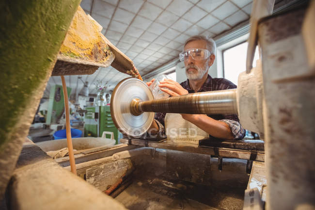 Glassblower polishing and grinding a glassware at glassblowing factory — Stock Photo