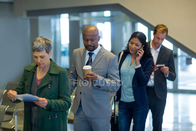 Viajeros de negocios esperando en cola en el aeropuerto - foto de stock