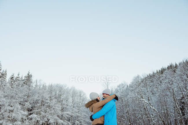 Feliz esquiador casal abraçando uns aos outros na montanha nevada — Fotografia de Stock