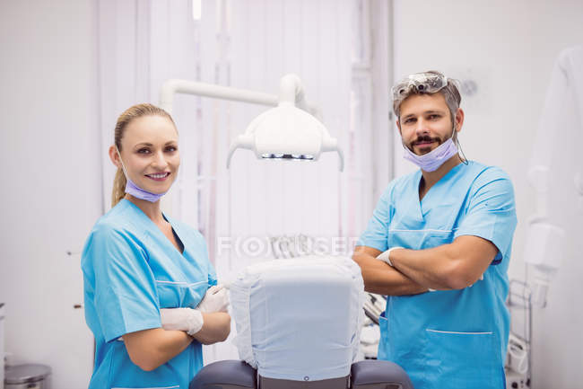 Retrato de dentistas de pie con los brazos cruzados en la clínica dental - foto de stock