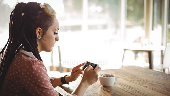Frau benutzt Handy in Café — Stockfoto