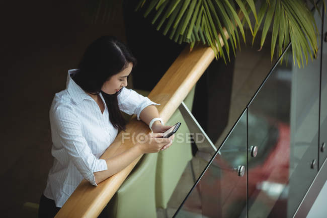 Деловая женщина с мобильного телефона на балконе офиса — стоковое фото