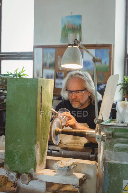 Полировка и шлифовка стеклодувов на стекольном заводе — стоковое фото