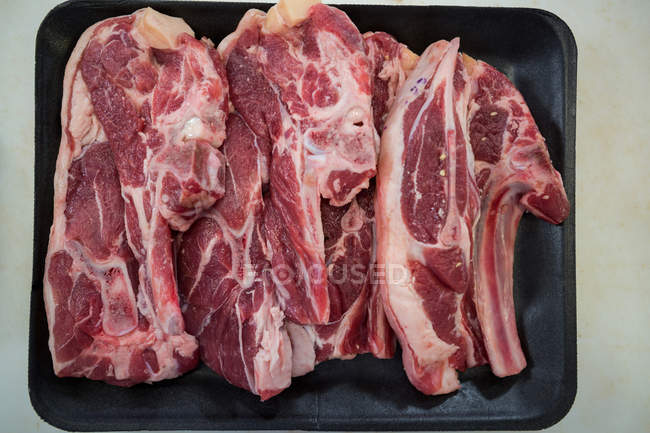 Primo piano di fette di carne in vassoio nero — Foto stock