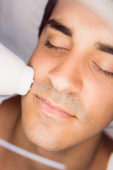 Homme se faire masser le visage pour un traitement cosmétique à la clinique — Photo de stock