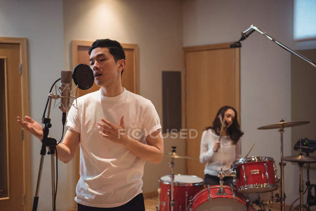 Young man singing in recording studio — Stock Photo