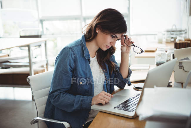 Executivo de negócios cuidadoso usando laptop no escritório — Fotografia de Stock