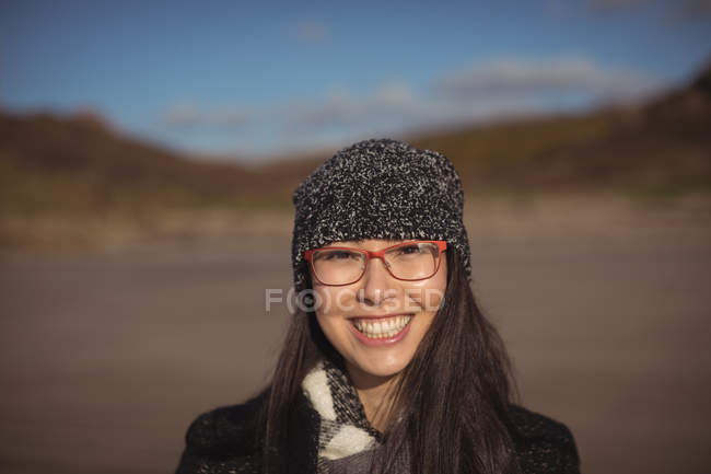 Retrato de la mujer de pie en la playa durante el día - foto de stock