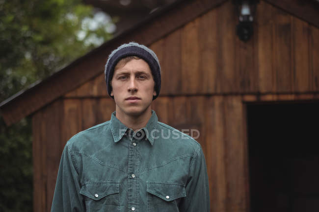 Portrait of man wearing woolly cap standing outside at home brewery — Stock Photo