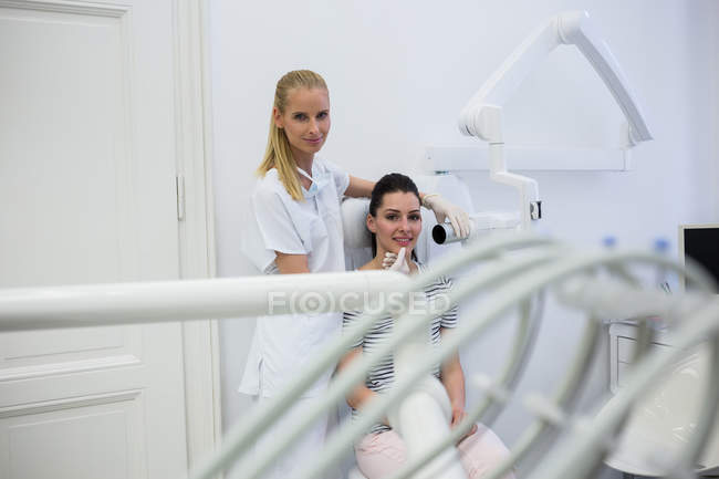 Retrato del dentista tomando rayos X de los dientes del paciente en la clínica - foto de stock