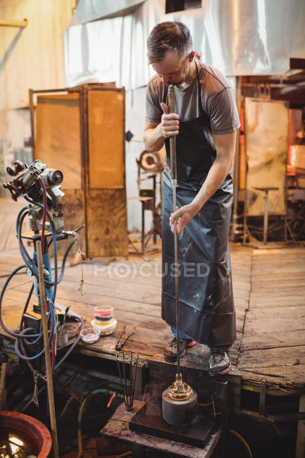 Glassblower using mold to shape a molten glass at glassblowing factory — Stock Photo