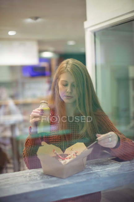 Frau mit Gesundheitsgetränk isst Salat im Restaurant — Stockfoto