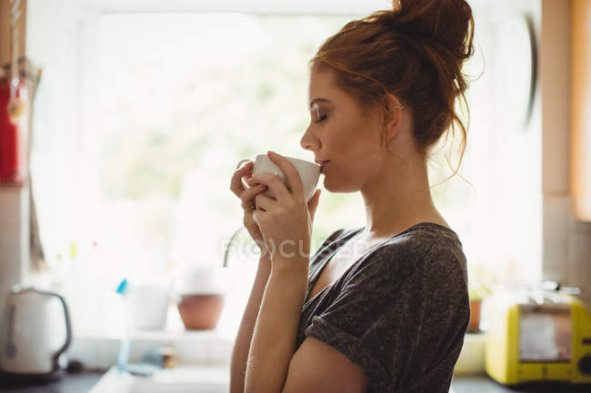 Belle femme prenant un café dans la cuisine à la maison — Photo de stock