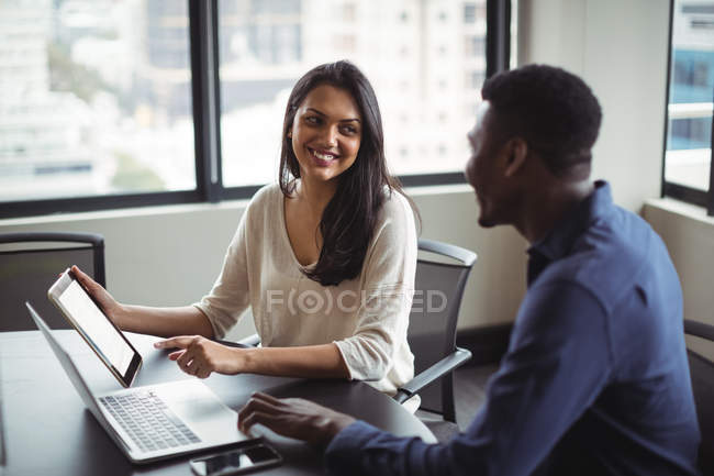 Homme d'affaires et un collègue discutant sur tablette numérique au bureau — Photo de stock