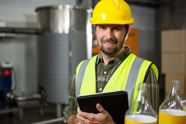 Retrato de homem sorridente trabalhador segurando tablet digital na fábrica — Fotografia de Stock