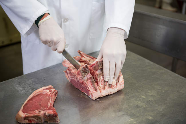 Close-up de carne de corte de açougueiro na fábrica de carne — Fotografia de Stock
