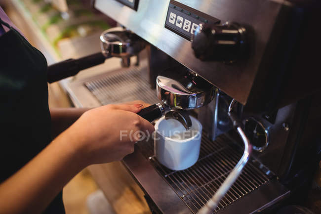 Nahaufnahme der Kellnerin, die in der Cafeteria Kaffee aus der Espressomaschine nimmt — Stockfoto