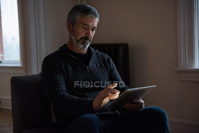 Man using digital tablet in living room at home — Stock Photo