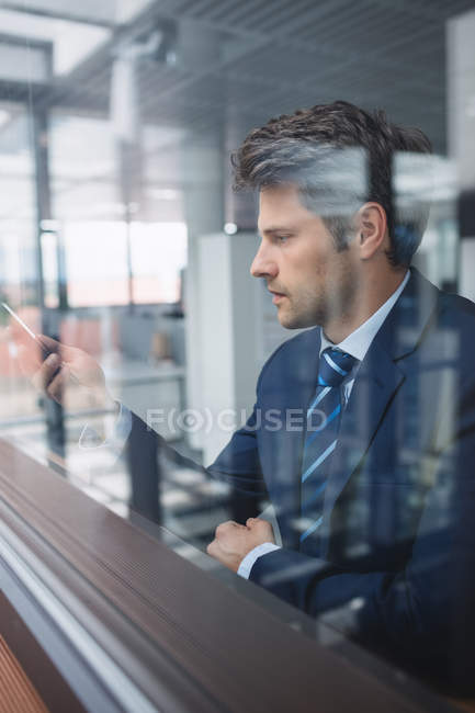 Hombre de negocios usando el teléfono móvil en la oficina - foto de stock