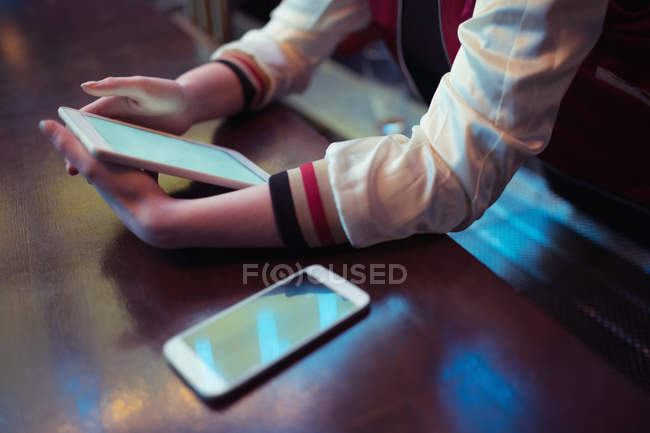 Frau benutzt digitales Tablet am Tresen in Bar — Stockfoto