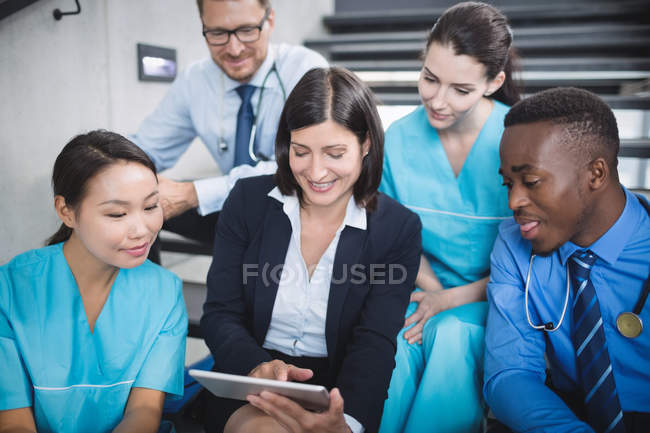 Médecins et infirmières regardant tablette numérique à l'hôpital — Photo de stock