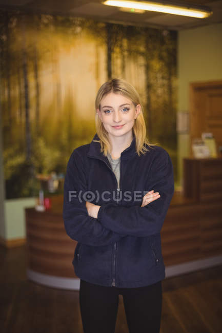 Portrait of confident woman standing with arms crossed in office — Stock Photo