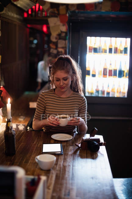 Mulher bonita tendo uma xícara de café no bar — Fotografia de Stock