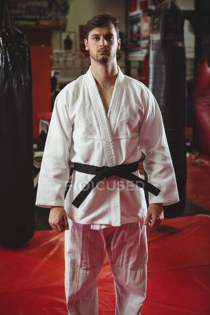Retrato del jugador de karate de pie en el gimnasio - foto de stock