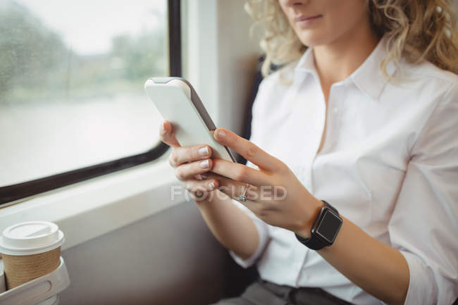 Cropped view of businesswoman using smartphone while travelling — Stock Photo
