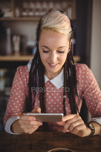 Женщина с помощью мобильного телефона в кафе — стоковое фото