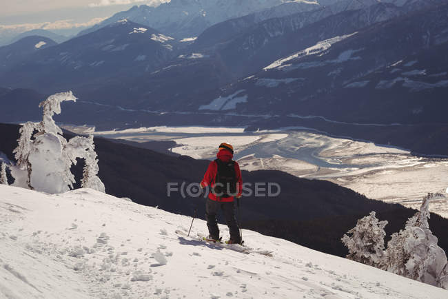 Rückansicht des Skifahrers beim Skifahren in den verschneiten Alpen im Winter — Stockfoto