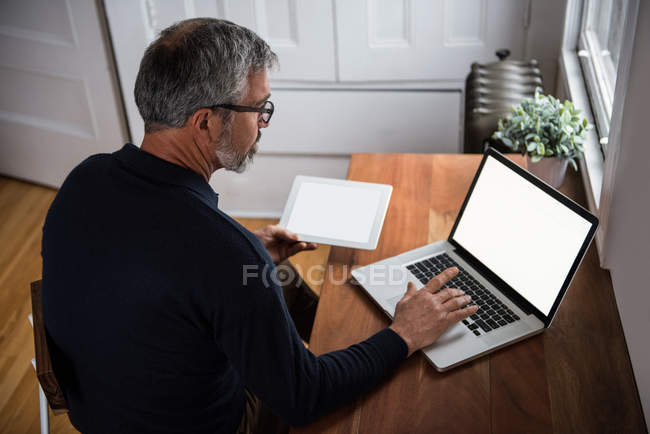 Homem usando laptop na sala de estar em casa — Fotografia de Stock