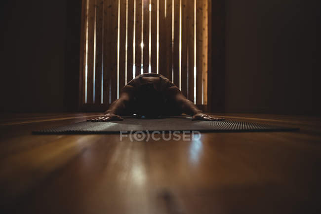 Donna che pratica yoga in palestra scura — Foto stock