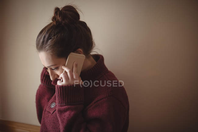 Красивая женщина разговаривает по мобильному телефону дома — стоковое фото