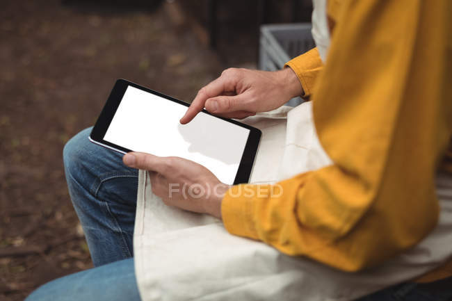 Seção média do homem em avental usando tablet digital em casa cervejaria — Fotografia de Stock
