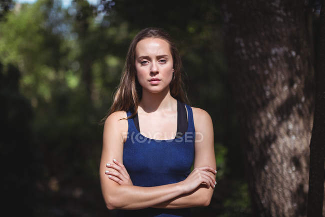 Портрет красивой женщины, стоящей со скрещенными в лесу руками — стоковое фото