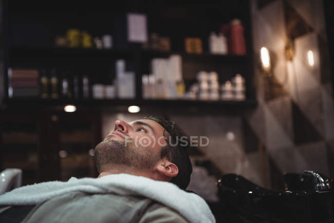 Client relaxing on chair in barber shop — Stock Photo