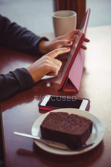 Primo piano della donna che utilizza tablet digitale nel ristorante — Foto stock