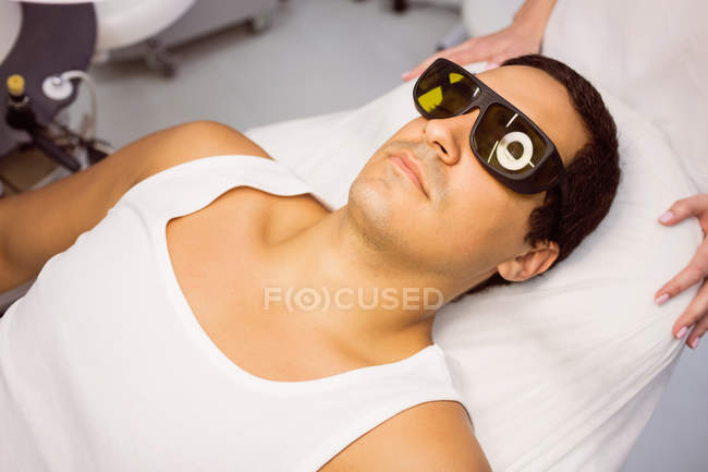 Paciente com óculos de proteção deitado para tratamento na clínica — Fotografia de Stock