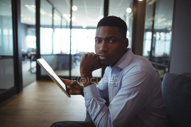 Ritratto di uomo d'affari con tablet digitale in carica — Foto stock