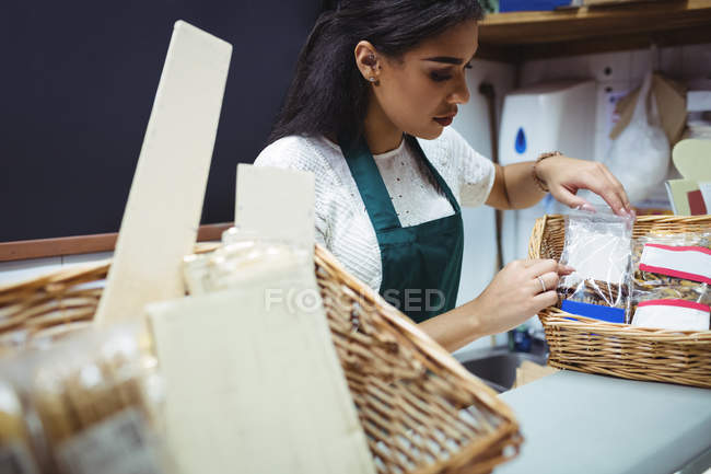 Personal femenino que trabaja en el mostrador de alimentos en el supermercado - foto de stock