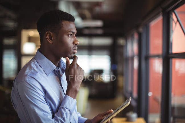 Бизнесмен с помощью цифрового планшета в офисе — стоковое фото