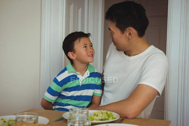 Pai e filho interagem enquanto tomam café da manhã em casa — Fotografia de Stock