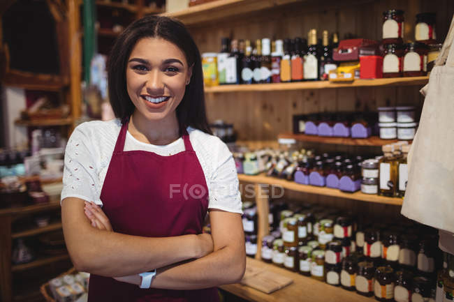Portrait of female staff standing with arms crossed in super market — Stock Photo