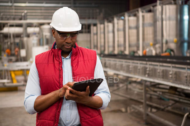Empregado masculino sério usando tablet digital na fábrica de suco — Fotografia de Stock