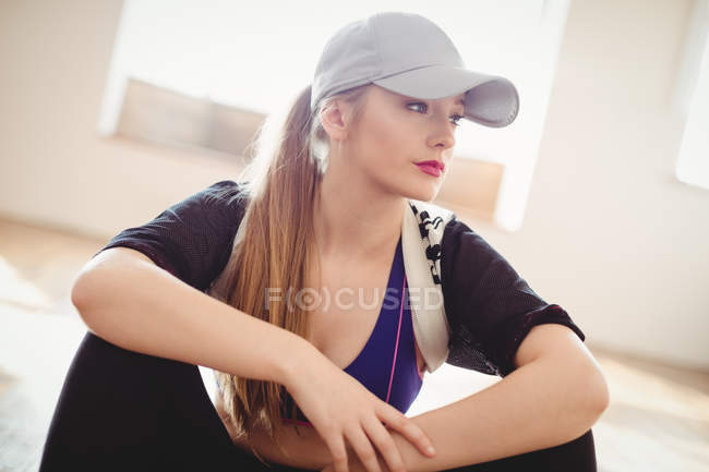 Mujer bastante reflexiva sentada en el estudio - foto de stock