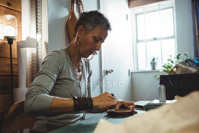 Artigiana che lavora su un pezzo di pelle in officina — Foto stock