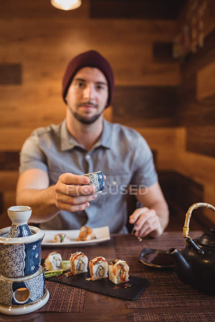 Portrait of man showing cup in restaurant — Stock Photo