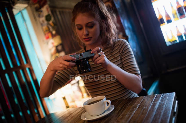 Mujer haciendo clic en una foto de café en el bar - foto de stock