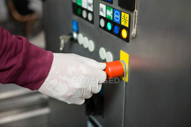 Cropped hand of worker operating machine in juice factory — Stock Photo